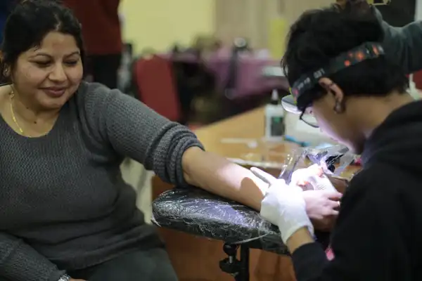 Emihang tattooing a volunteer at the Human Rights Tattoo event in Nepal
